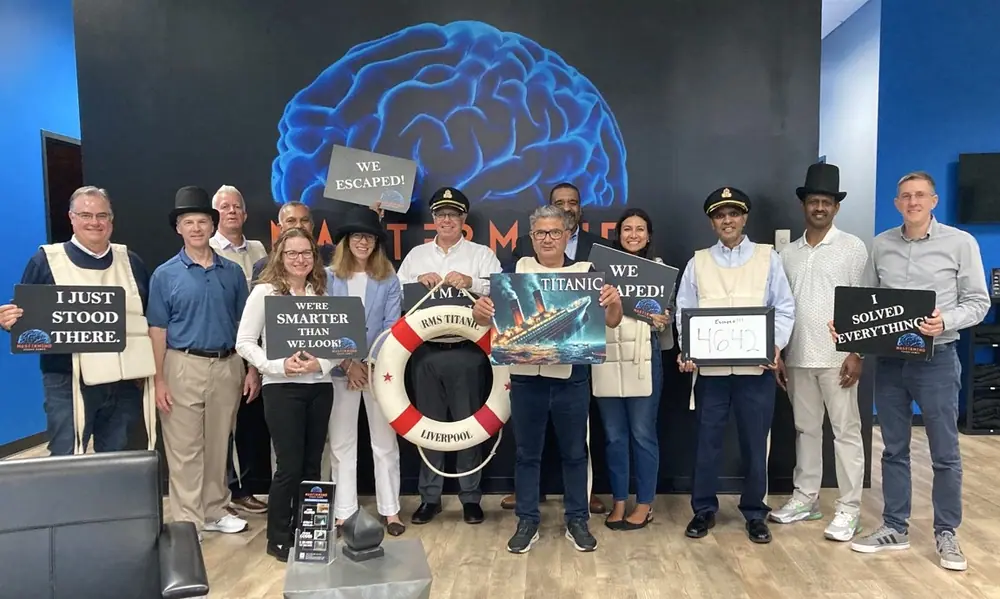 A large group in Titanic captain’s hats and life vests, holding a life ring and “We escaped!” signs